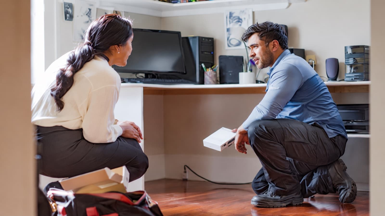 Illustrative home scene of a resident speaking with an internet technician