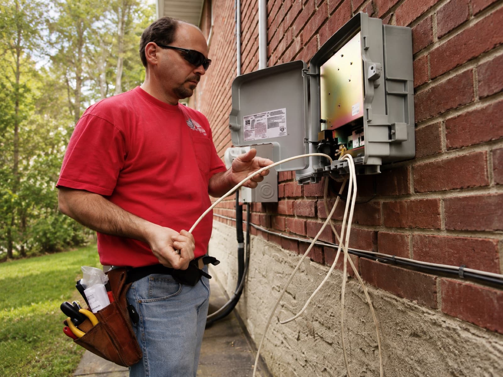 Illustrative outdoor scene of a technician working on a wall-mounted internet utility box